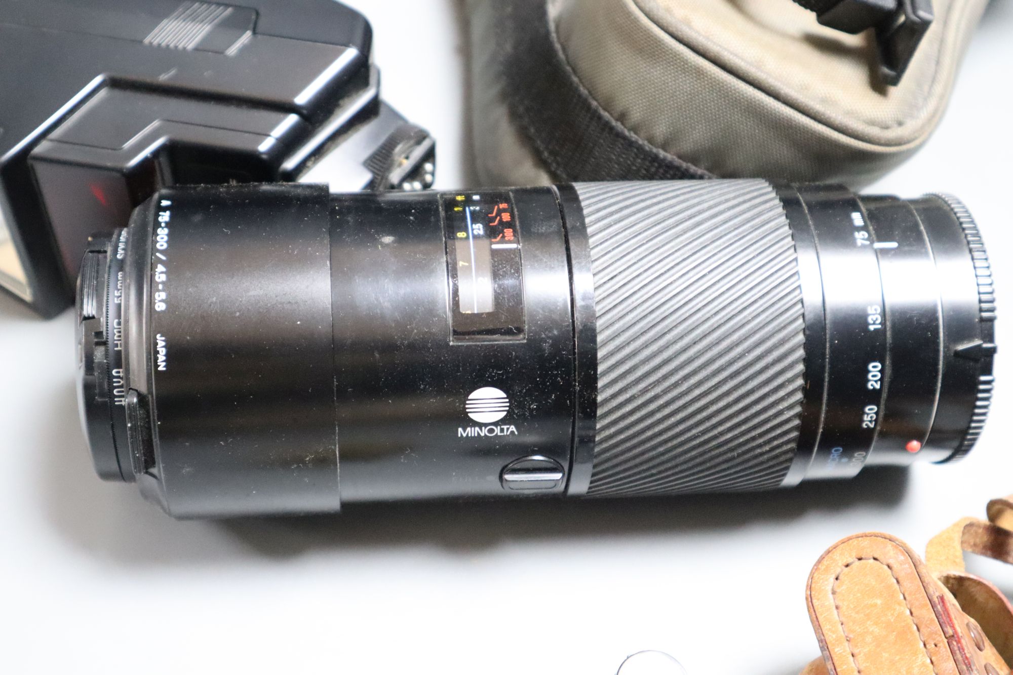 A Minolta 9000 SRL camera, a Minolta 75-300 zoom lens, with flash, together with a Sanwa Mycro miniature camera, with leather case